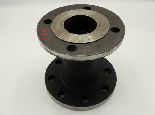 Passstück aus Metall mit einer Befestigungsfläche und mehreren Bohrungen, gefertigt von Remeha. Das Teil ist schwarz lackiert mit einer glatten, silbernen oberen Fläche.